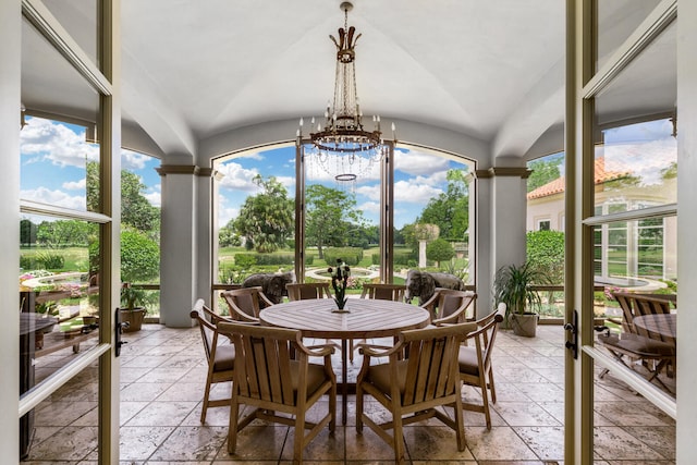 sunroom / solarium with a notable chandelier, lofted ceiling, and a wealth of natural light