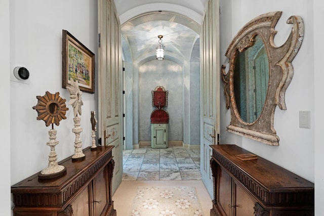 hall with arched walkways and marble finish floor