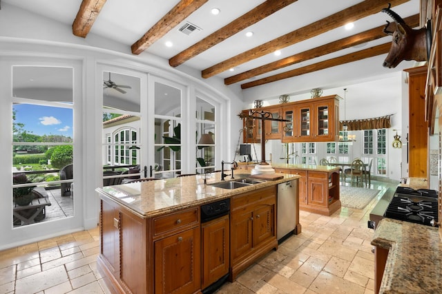 kitchen with visible vents, dishwasher, stone tile floors, brown cabinets, and a sink