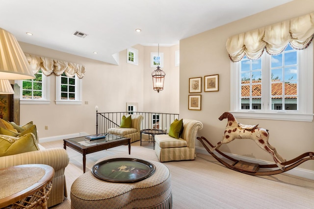 living area featuring baseboards, visible vents, recessed lighting, carpet flooring, and a chandelier