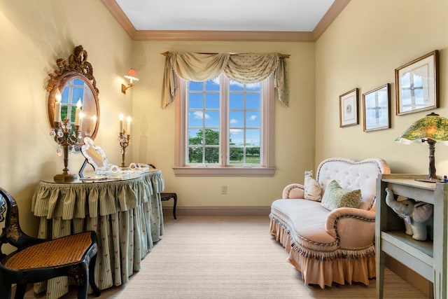 sitting room with baseboards, light carpet, and crown molding