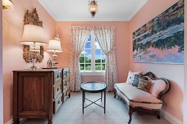 sitting room with baseboards and crown molding