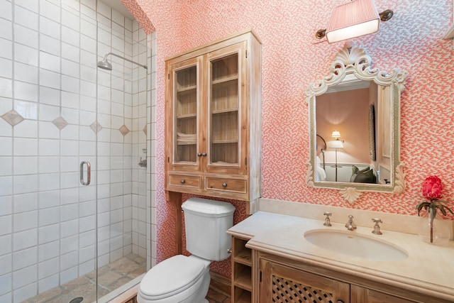 bathroom featuring vanity, toilet, and a shower with door