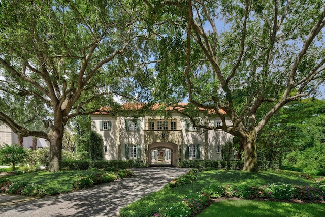 mediterranean / spanish house featuring stucco siding and a front lawn