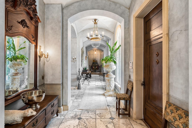 interior space featuring vaulted ceiling, an inviting chandelier, and light tile floors