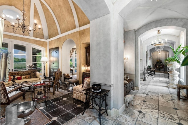 interior space featuring stone tile flooring, a chandelier, arched walkways, and lofted ceiling