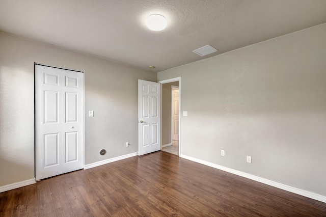 unfurnished bedroom with dark wood-style floors and baseboards