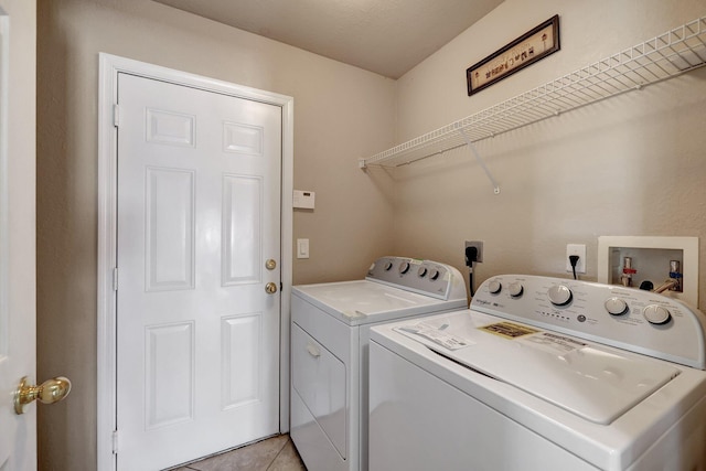 washroom featuring light tile patterned floors, laundry area, and washing machine and clothes dryer