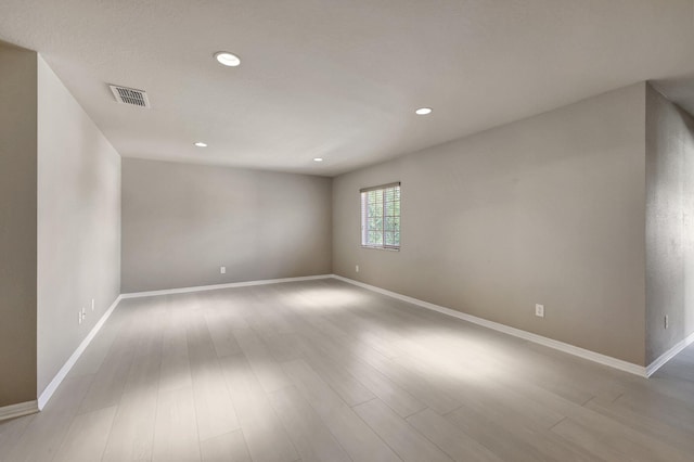 unfurnished room featuring visible vents, recessed lighting, wood finished floors, and baseboards