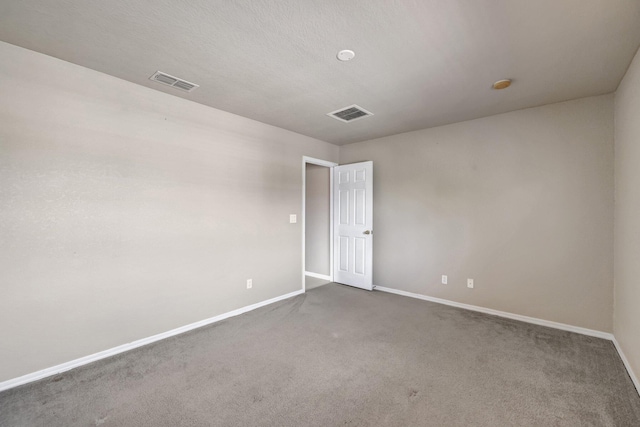 spare room with visible vents, baseboards, and carpet