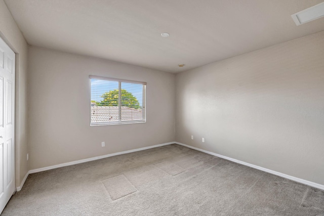 spare room with visible vents, light colored carpet, and baseboards