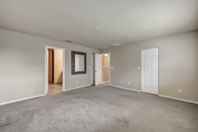 unfurnished bedroom with visible vents, carpet floors, a textured ceiling, and baseboards