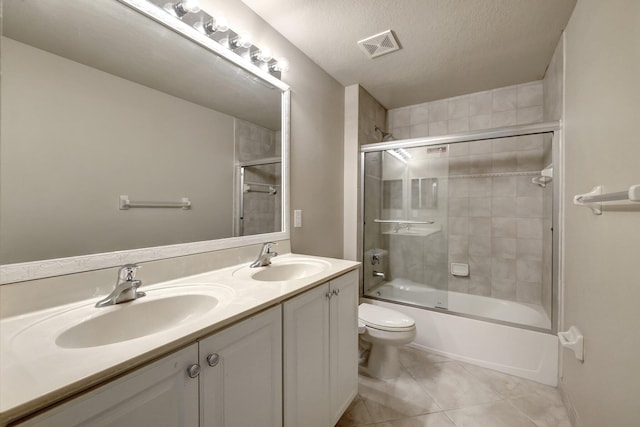 full bath with a sink, visible vents, toilet, and tile patterned flooring