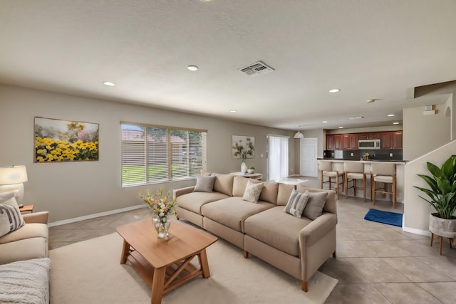 living area with recessed lighting, light tile patterned floors, baseboards, and visible vents