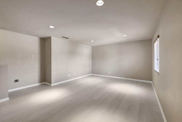 empty room with recessed lighting, wood finished floors, visible vents, and baseboards