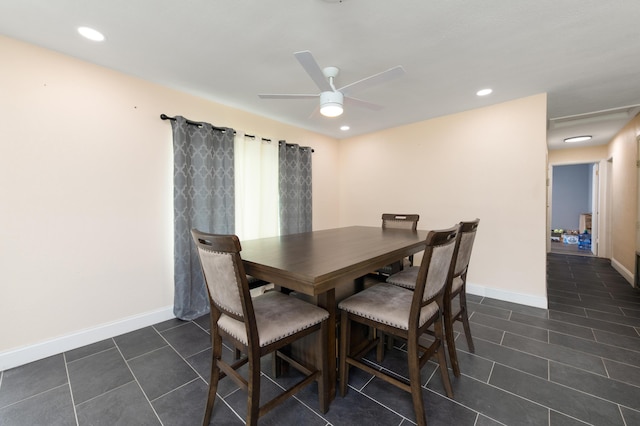 dining space featuring dark tile patterned flooring and ceiling fan