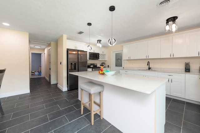 kitchen featuring white cabinets, pendant lighting, stainless steel appliances, and a kitchen island