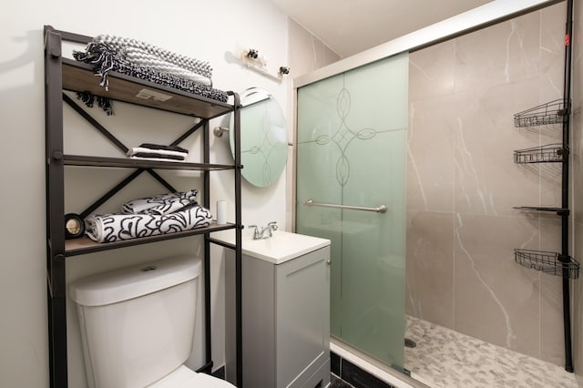 bathroom with toilet, walk in shower, and sink