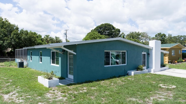 exterior space with a lawn and central AC unit