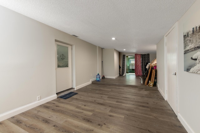 corridor featuring dark hardwood / wood-style flooring and a textured ceiling