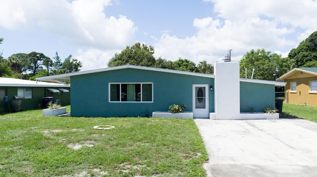 1013 Hispana Ave, Fort Pierce, FL 34982 - view of front of home with stucco siding, a front lawn, and a chimney