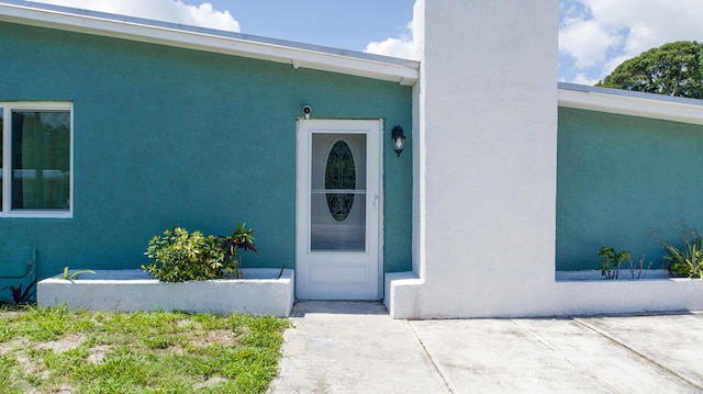 1013 Hispana Ave, Fort Pierce, FL 34982 - doorway to property with stucco siding and a patio