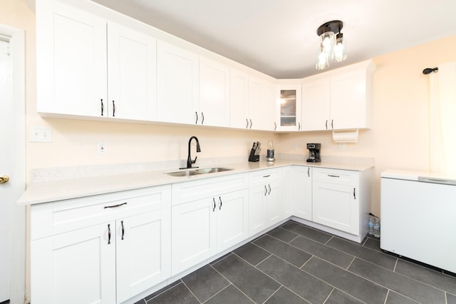 kitchen with sink, hanging light fixtures, fridge, white cabinets, and dark tile patterned flooring