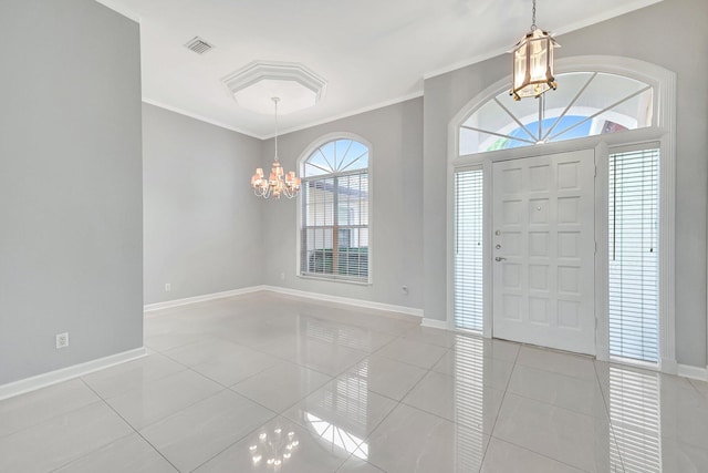 foyer entrance featuring light tile patterned flooring, crown molding, and a healthy amount of sunlight