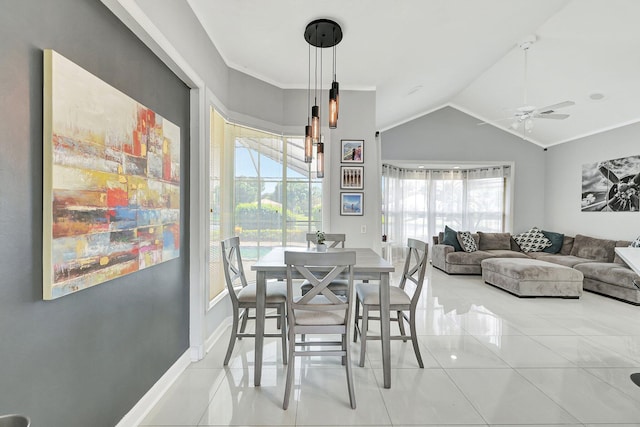 tiled dining space featuring crown molding, vaulted ceiling, and ceiling fan