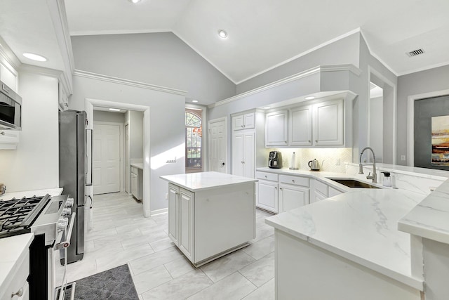 kitchen featuring decorative backsplash, sink, a center island, appliances with stainless steel finishes, and lofted ceiling