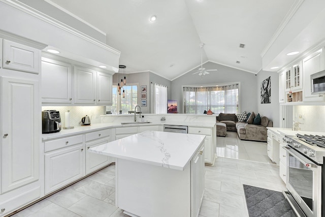 kitchen with white cabinetry, lofted ceiling, appliances with stainless steel finishes, and a kitchen island