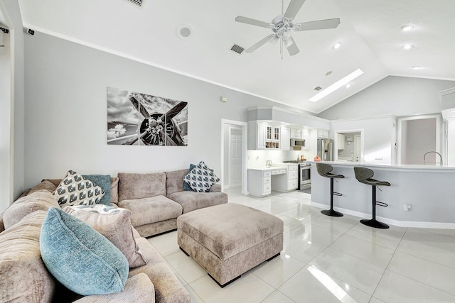 living room featuring light tile patterned flooring, ceiling fan, vaulted ceiling, and crown molding