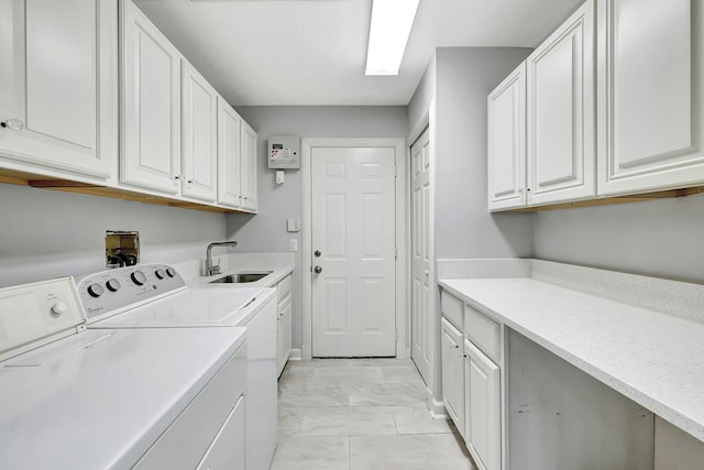 clothes washing area with washing machine and clothes dryer, sink, cabinets, and light tile patterned floors