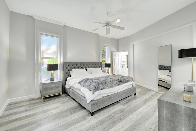 bedroom featuring ceiling fan, multiple windows, and light hardwood / wood-style flooring