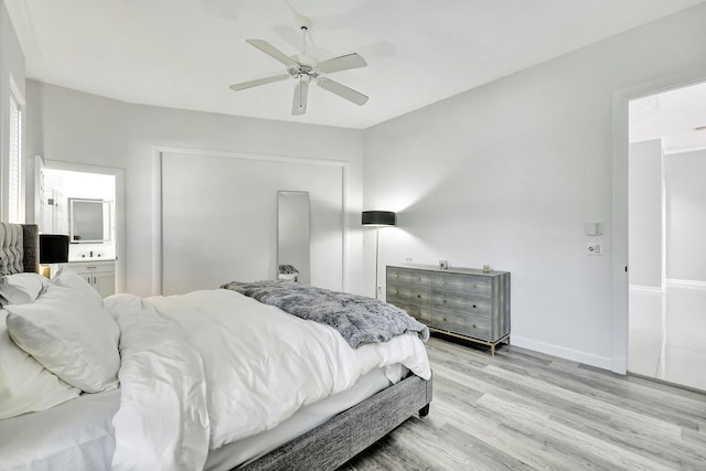 bedroom with ensuite bath, ceiling fan, and light hardwood / wood-style flooring