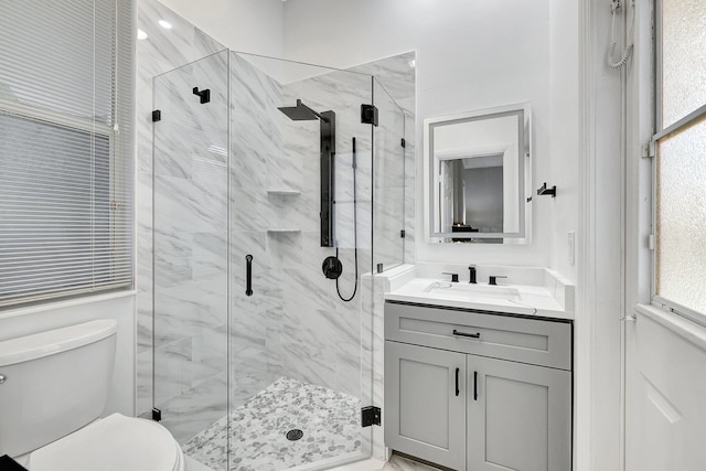 bathroom featuring vanity, walk in shower, and toilet