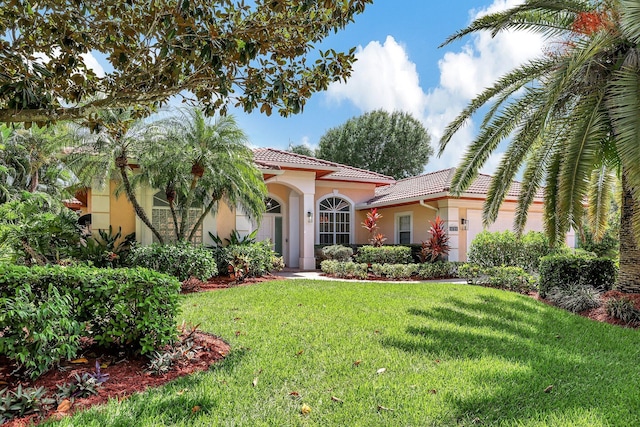 mediterranean / spanish home featuring a front lawn