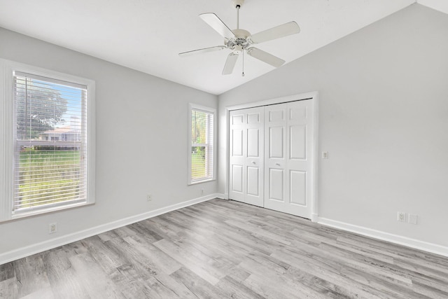 unfurnished bedroom featuring light hardwood / wood-style floors, vaulted ceiling, a closet, and ceiling fan