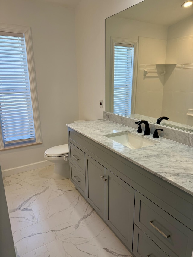 full bathroom featuring walk in shower, vanity, toilet, marble finish floor, and baseboards