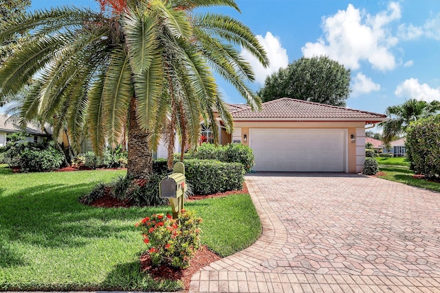 mediterranean / spanish home featuring a garage and a front yard