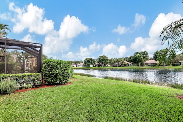 view of yard with a water view and a lanai