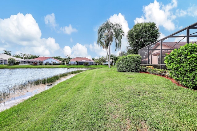 view of yard featuring a lanai, a water view, and a residential view