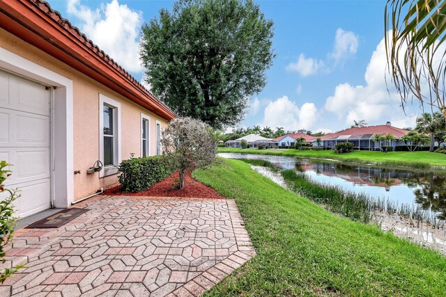 view of yard featuring a residential view, a water view, and a patio area