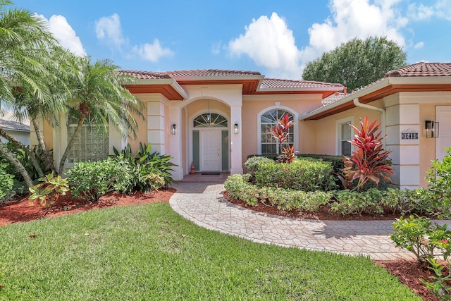 mediterranean / spanish-style house with a front yard