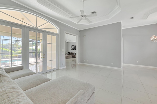 living room with french doors, light tile patterned floors, ornamental molding, a raised ceiling, and ceiling fan