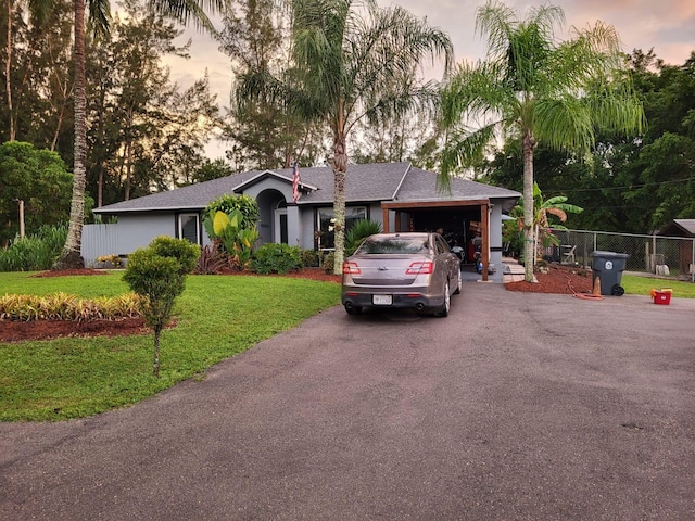 ranch-style home featuring a lawn and a garage