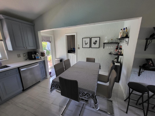 dining room featuring wet bar and lofted ceiling