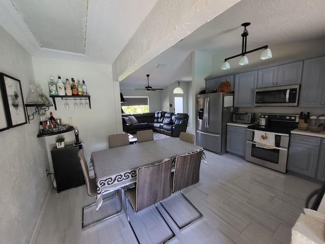 kitchen with a textured ceiling, stainless steel appliances, gray cabinets, and ceiling fan