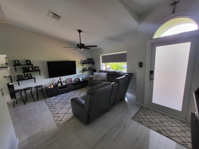 living room featuring ceiling fan, lofted ceiling, and a wealth of natural light