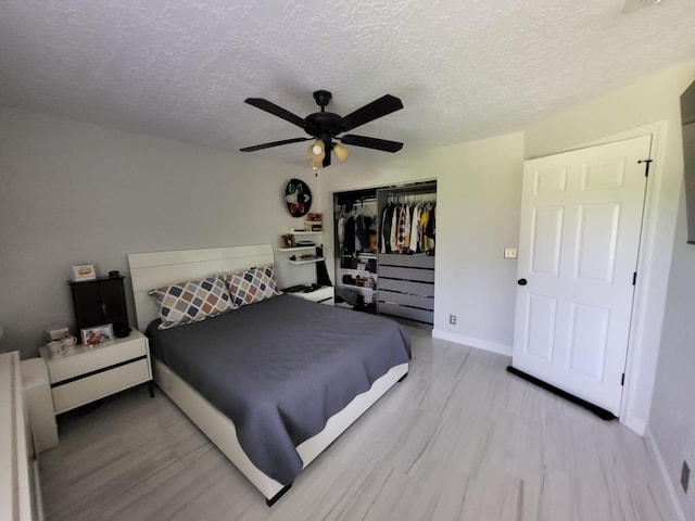 bedroom with ceiling fan, a closet, and a textured ceiling